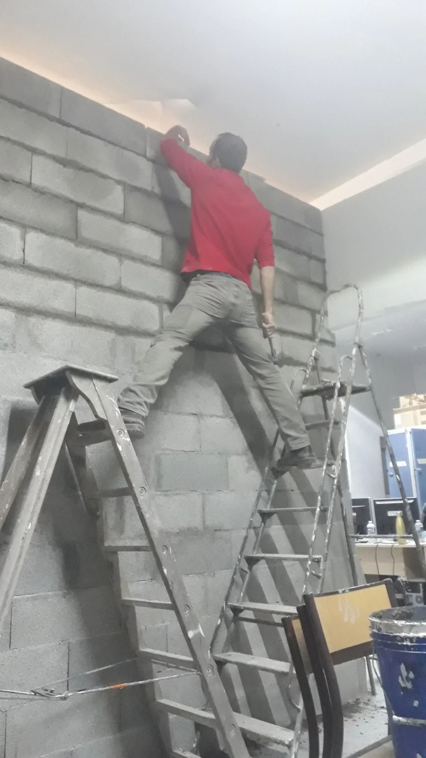 Bénévole construisant un mur du hall d'accueil pendant les travaux